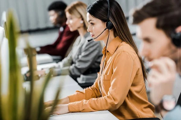 Call center operátorok dolgoznak, headsettel és számítógéppel.