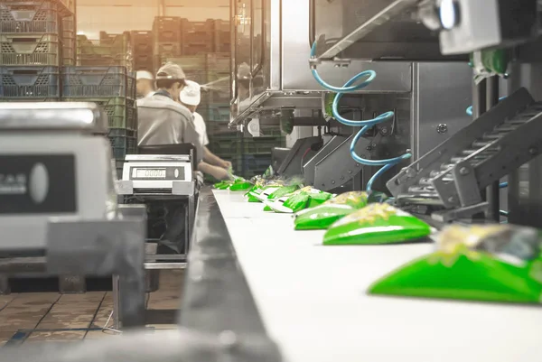 Csomagolóüzem belső tere, ahol tejtermékeket csomagolnak gépek segítségével.