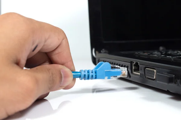 Kék LAN kábel csatlakoztatása egy laptophoz, amely az internetkapcsolatot biztosít.